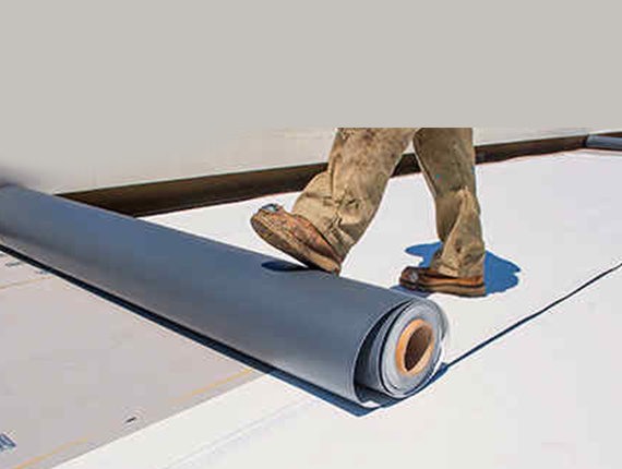 Man rolling out roof sealing product